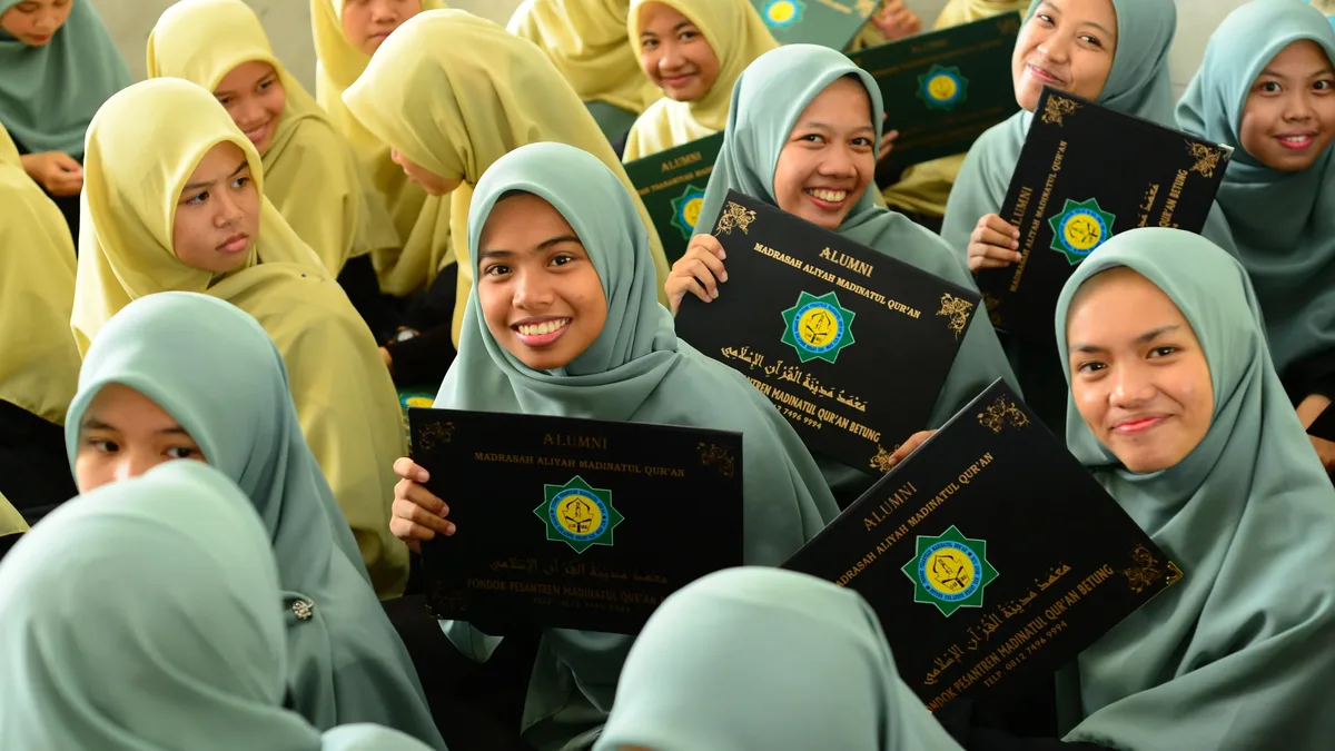 A group of women in hijabs holding certificates.