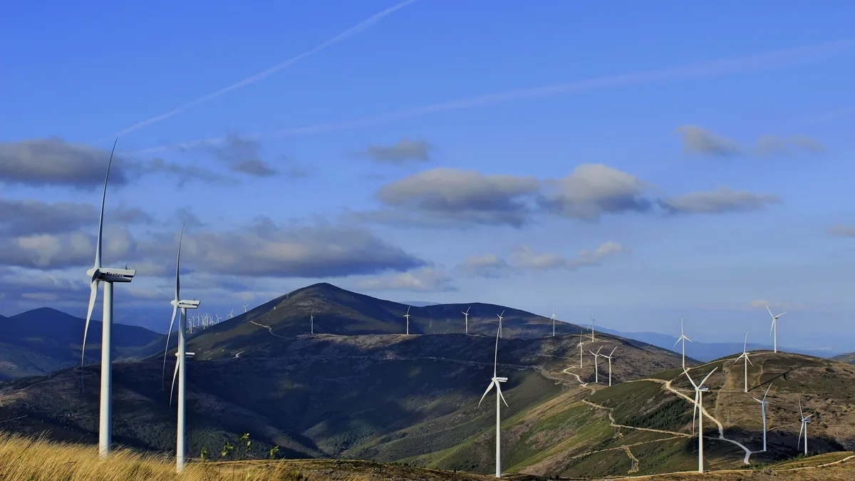 A wind farm is visible, featuring multiple wind turbines situated on a hillside.